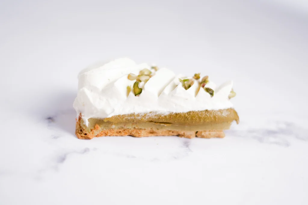 La découpe de la tarte à la pistache et fleur d'oranger sans sucre blanc et sans gluten