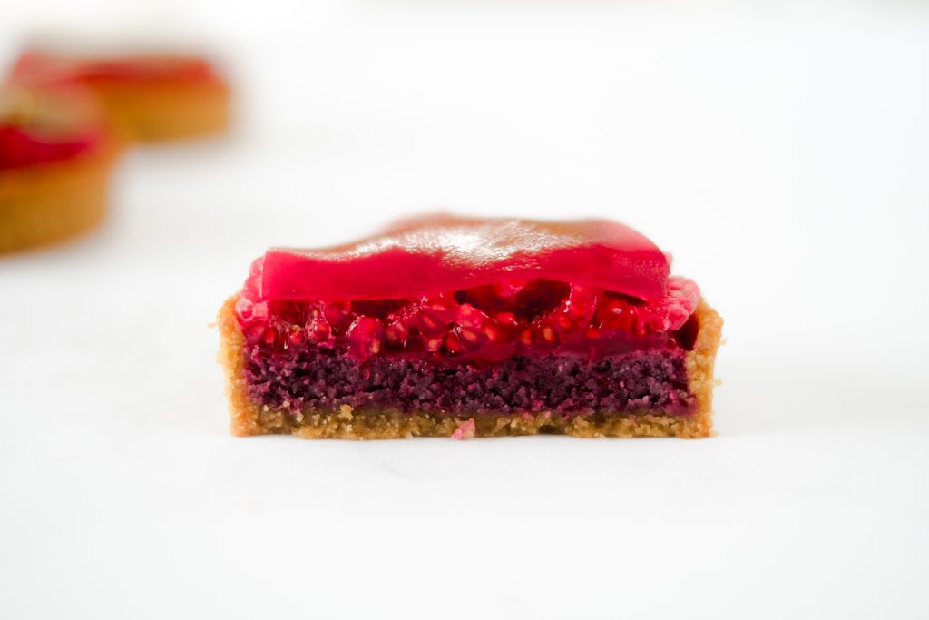 La découpe de la tartelette framboises hibiscus sans sucre raffiné et sans gluten